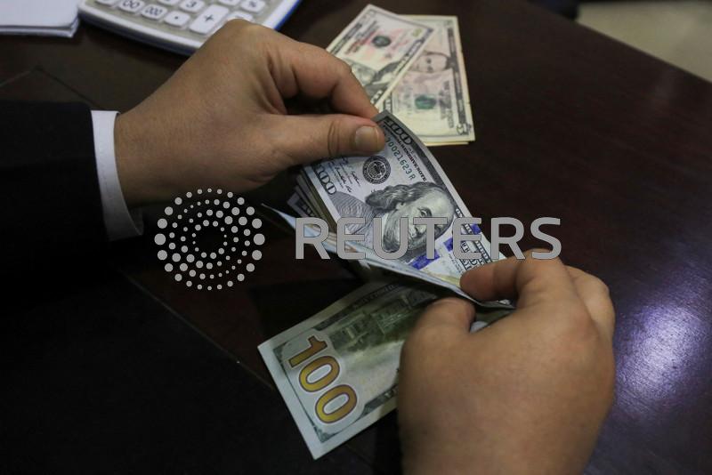 Dollar edges down towards one-week low as market ponders Trump tariffs